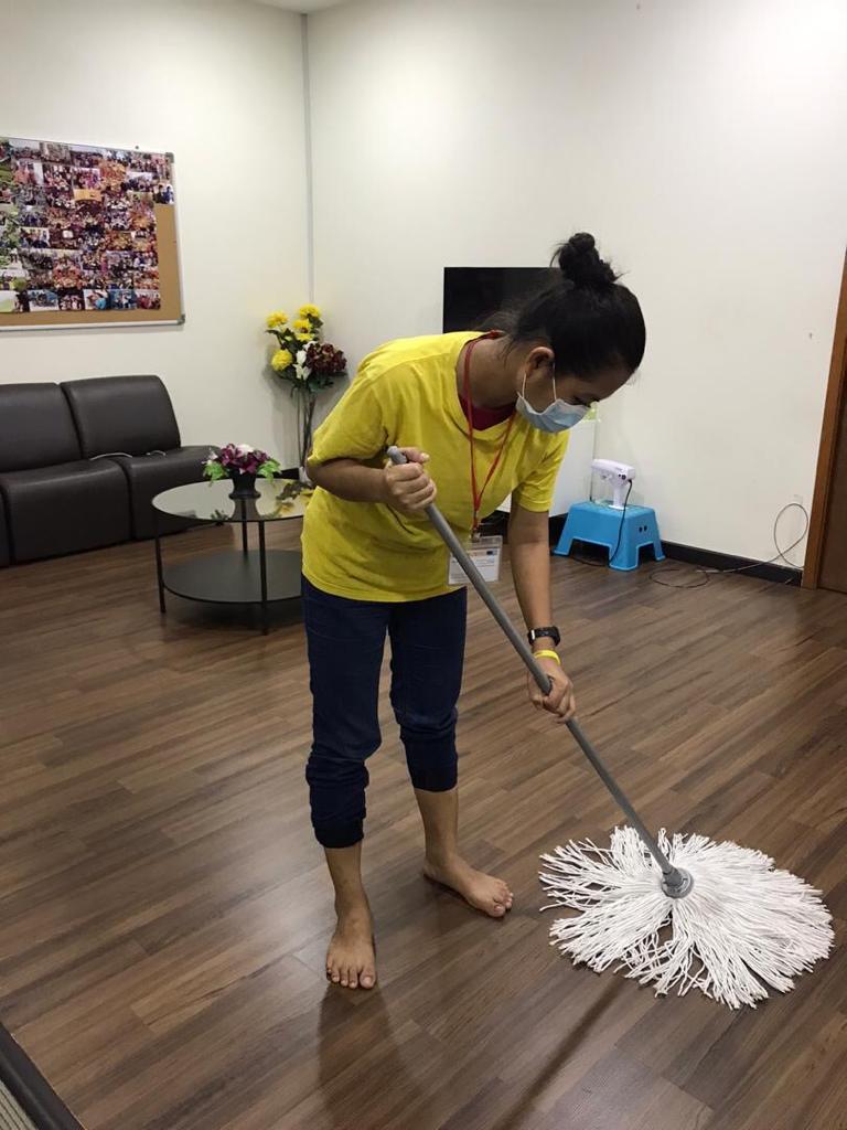 Angel Cleaning team member mopping a living room